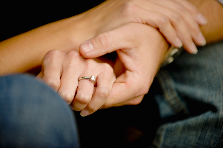 A close up of a couple holding hands.